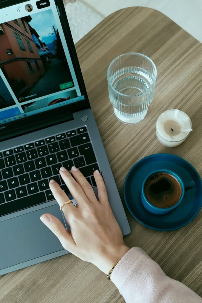 Przytulne biurko z laptopem, kawą i wodą, idealne do pracy nad Shopify.